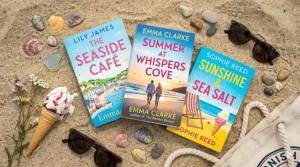 A detailed flat lay photograph of three feel-good summer novels on sand surrounded by seashells, sunglasses, and a melting ice cream cone on a British beach.