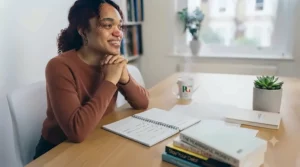 A person smiling while checking their financial independence and early retirement milestone tracker.